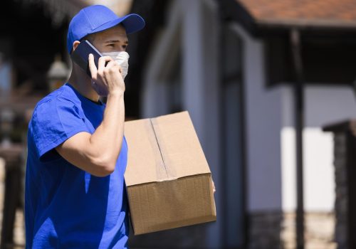 delivery-man-with-face-mask-carrying-parcel